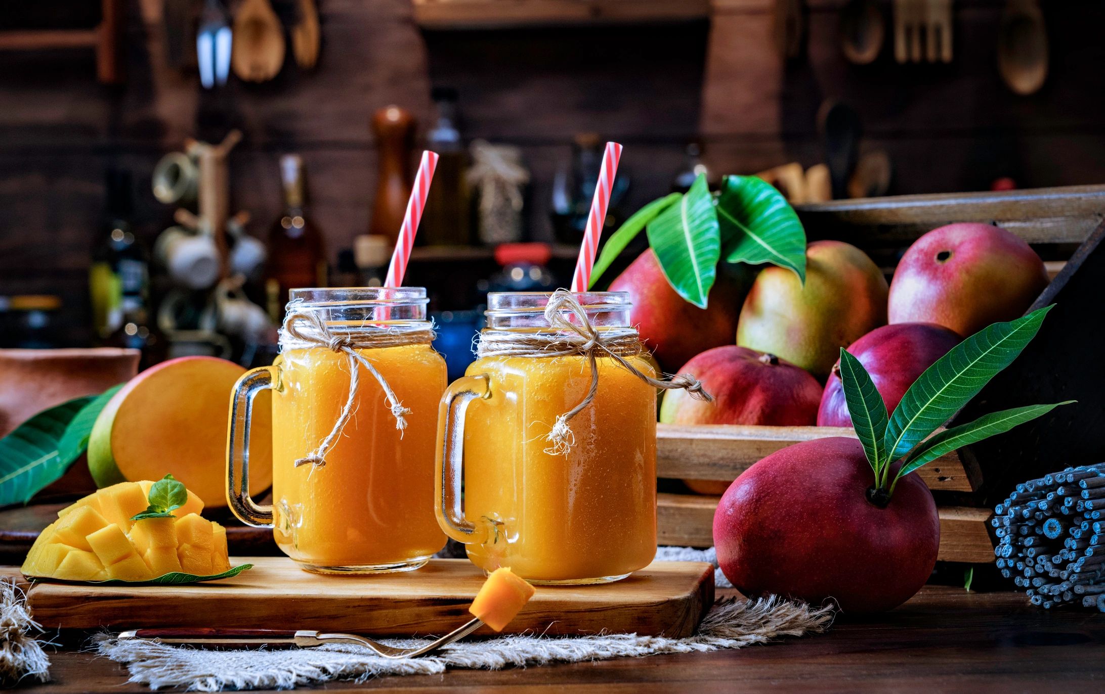 Tarros con jugo de mango y fruta sobre mesa