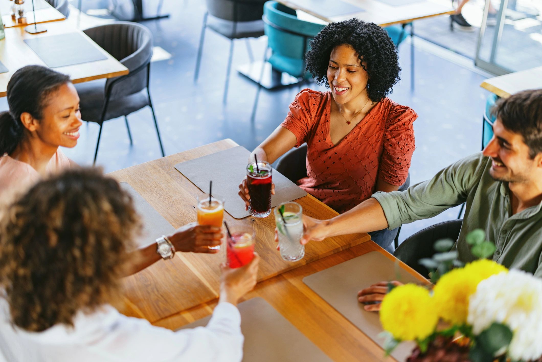 Grupo de amigos brindando con bebidas sin alcohol en restaurante